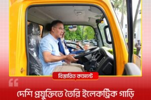 Man in a light blue shirt sits in the driver’s seat of a yellow truck cab, talking to someone off‑camera during a news interview.