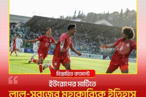 Football players in red kits celebrate a goal on a sunlit soccer field, with a cheering crowd in the background.